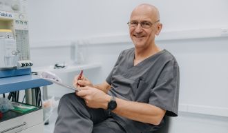 Anästhesist dokumentiert Patientendaten neben Narkosegerät, professionelle Vorbereitung in moderner Anästhesiepraxis