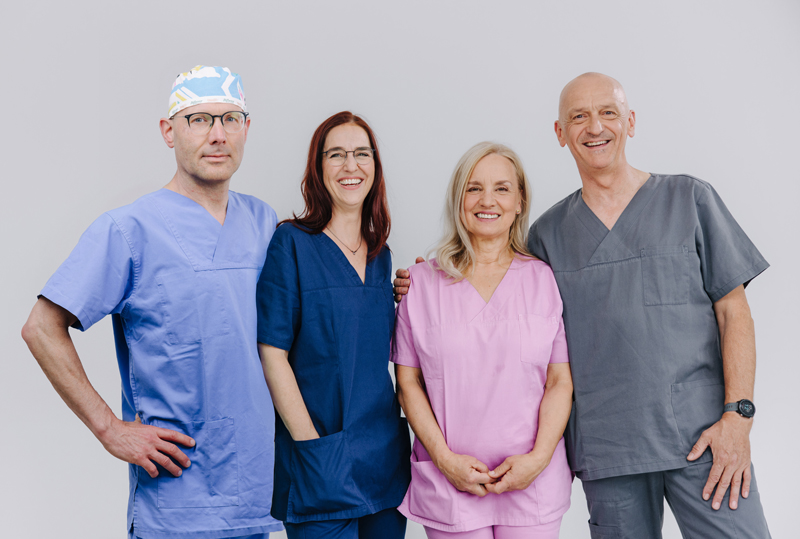 Lachendes Anästhesie-Team in OP-Kleidung, sympathisches Gruppenfoto der Gemeinschaftspraxis für Anästhesie