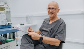 Anästhesist dokumentiert Patientendaten neben Narkosegerät, professionelle Vorbereitung in moderner Anästhesiepraxis