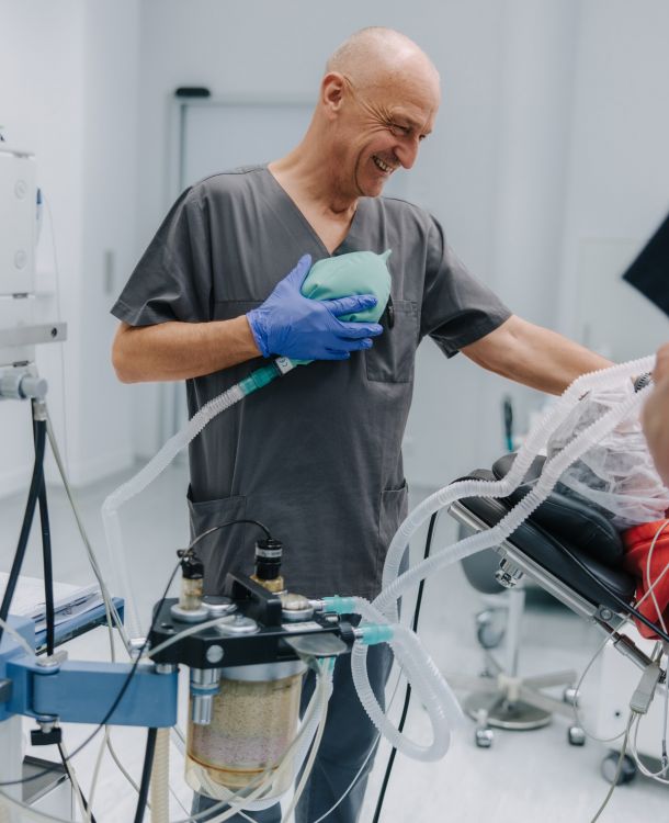 Anästhesist bedient Beatmungsbeutel und Narkosegerät, Vorbereitung auf Anästhesie im OP, moderne Anästhesiepraxis